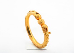 Golden bangle with beautiful work side view ideal for wedding isolated on white background. Gold jewellery stock photo.