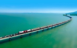 Aerial view of Travel train parked on a floating railway bridge over the clear water of lake in Pa Sak Jolasid dam with blue sky at Lopburi, amazing Thailand.	
