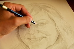 artist drawing woman portrait with a pencil.