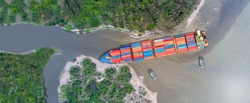 Canal blocked by huge cargo container ship; Aerial top view of accident container ship a stranded ship with salvage crews across the canal concept accident safety and insurance.