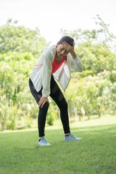 Woman gets heatstroke, Sport woman gets in pink sport shirt Dizzy and Faint when she jogging or exercise outdoor with strong sunlight in summer season in Green City Park. She will be fainting 