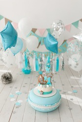 Incredibly beautiful cream cake in mint and white, timed to the first birthday, decorated with a paper garland, gingerbread