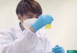 Scientist analysis the results of Coliform bacteria test kit, E.Coli testing technique for counting the Coliform bacteria. By observe gas air and color changed to yellow in the vial holding in hands.