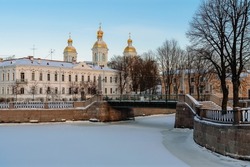 View of the Krasnogvardeysky Bridge over the Griboyedov Canal and the dome of the St. Nicholas Naval Cathedral on a sunny winter day, St. Petersburg, Russia
