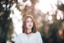 Portrait of young hipster Asian girl  posing in the autume park forest bokeh background