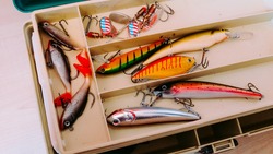 Fishery utensils. Close up picture of professional fishing box with many colorful bait, lures and accessories