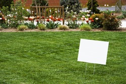 Blank white sign on newly cut grass. Copy space. Horizontal.