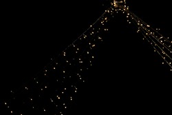 String of Lights with yellow light bulbs hanging from the ceiling with deep black background with space for text