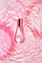 Perfume on water pink rose texture waves. Flat lay. Empty space mockup.