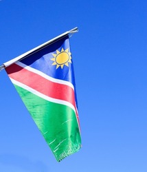 Namibian Flag sways proudly in the wind, against a bright blue African Sky