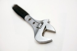 Modern adjustable wrench on a white background close-up. The concept of a tool for repair or construction. Special tool for repairing pipes and clamping nuts with adjustment