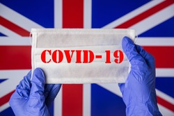 Coronavirus outbreak. Coronavirus update in Great Britain. Word Covid-19 on medical mask with flag of UK on background. Spread of corona virus in world. Wuhan virus. Stay at home during quarantine. 