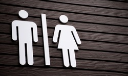 Restroom sign on a toilet door,on wood background.Toilet sign - Restroom Concept - black tone.WC / Toilet icons set. Men and women WC signs for restroom.