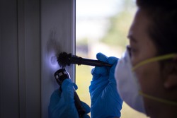 Forensic expert finds fingerprints on the window at the crime scene