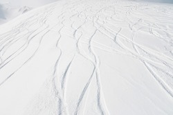 top view of the snow-covered slope of the mountain, traces from skiers and snowboarders, no people