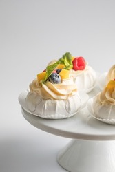 Mini Pavlova Cake meringue dessert with crisp crust and soft inside. Meringue dessert Pavlova cake with fresh raspberry mango slice and mint. Confectionery. Classic dessert