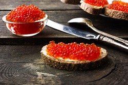 red caviar on black bread with butter. rural blue background. vintage style. Healthy food. Fish appetizer. 