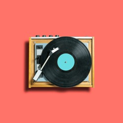 vintage turntable vinyl record player on coral background. retro sound technology to play music. trendy 2019 color concept