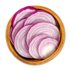 Cross sections of red onions in wooden bowl. Slices of the onion cultivar Allium cepa with purplish red skin and white flesh tinged with red. Closeup from above, over white, isolated macro food photo.