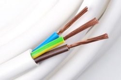 Electrical power cable macro photo. IEC standard color code. Cross-section with cable jacket, wire insulations in brown, blue and yellow-green color with flexible stranded copper wires. Close up.