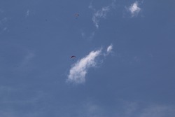 Para gliders flying high in a blue sky