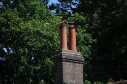 Two tall chimney pots on a brick chimney stack