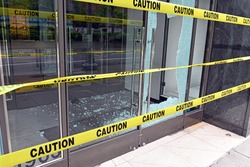 Broken glass window on retail store front from criminals looting and rioting in Manhattan New York during racial protests
