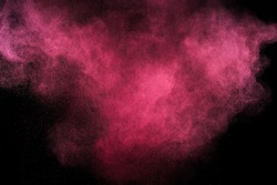 Magenta powder explosion on black background. Pink cloud. Red dust explode. Freeze motion paint Holi.