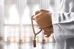 Religious muslim man praying with rosary beads