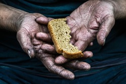 Dirty hands homeless poor man with piece of bread in modern capitalism society. Economic recession, unemployment, poverty, hunger, retirement, global crisis, 	inequality problem concept. 