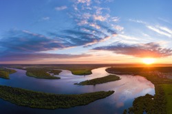 Aerial panoramic landscape with sunset over the river with islands and beautiful clouds on the sky.