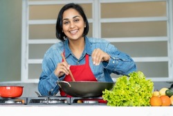 Mature latin american woman preparing vegetarian food at kitchen