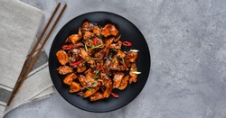 spicy chicken in sweet and sour sauce with chili pepper. teriyaki chicken's  with  sesame seeds. Chinese cuisine, Thai cuisine. Japanese food, copy space, recipe background, food flat lay