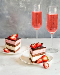 Festive strawberry cake on a plate. Dessert for your birthday. A surprise for women. Pink champagne and strawberries