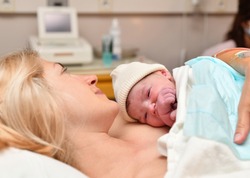 Mom and newborn baby skin to the skin after birth in the hospital