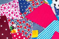 The texture of large scraps of colored fabrics as a background or backdrop, home patchwork crafts or creativity