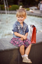cute smiling little girl on shopping outdoors