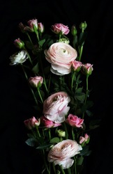 Pink flowers ranunculus and pink roses  bouquet on black background top view. Low key style. Poster