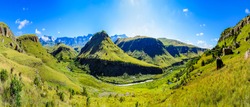 South Africa Drakensberg scenic panoramic impressive landscape view -  green Giants Castle wide panorama with sunny blue sky - mountains valley,creek,grass, bright,horizon,clouds,travel,stunning