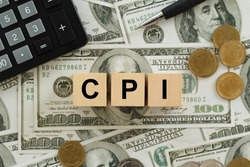 CPI, consumer price index symbol. Wooden blocks with words CPI, consumer price index on dollar bills with a calculator, coins.  Business and CPI, Business and consumer price index concept.