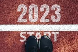 Start 2023 year concept, top view of man shoe on an athletics track engraved with the year 2023.Start of the new year 2023, goals and plans for the next year.Opportunity, challenge,Goal of Success