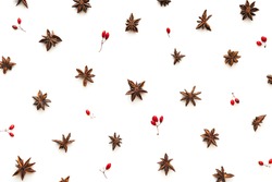 Christmas pattern with anise stars and red berries isolated on white. Flat lay. View from above.