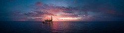 Aerial panorama view from a drone of an offshore jack up rig during sunset time at the offshore location