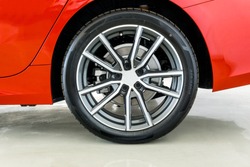 Image of rear side sports car wheel with number and markings on tire sidewall Which indicates the size of the tire ,age, load of the tire