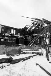 Photo of a burnt house in winter. Charred beams of a wooden house. Burned down house.