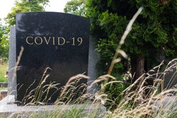 Headstone tombstone or gravestone with COVID-19 letters carved in, Coronavirus global pandemic crisis, many victims and deaths, deadly virus disease, acute respiratory pneumonia infection, RIP concept