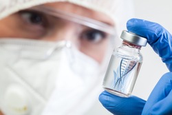 Female NHS UK lab microbiologist biotechnician holding glass bottle vial with DNA helix strand float in liquid,Coronavirus new strain mutation,novel Omicron variant,COVID-19 pandemic crisis outbreak