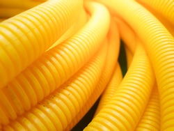 Roll of yellow plastic corrugated, Electric tube hose conduit installation in building construction site.