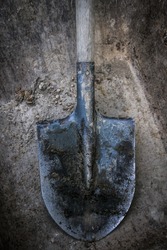 Dirty shovel in fresh soil.
