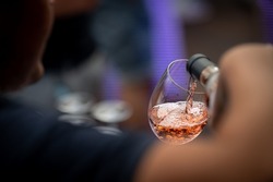 hand with a glass of rosé wine at a wine tasting